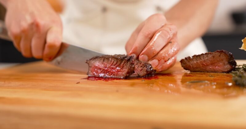 Chef cutting a slice of a steak