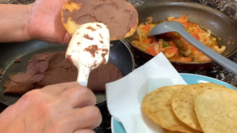 Spreading tortillas with refried beans